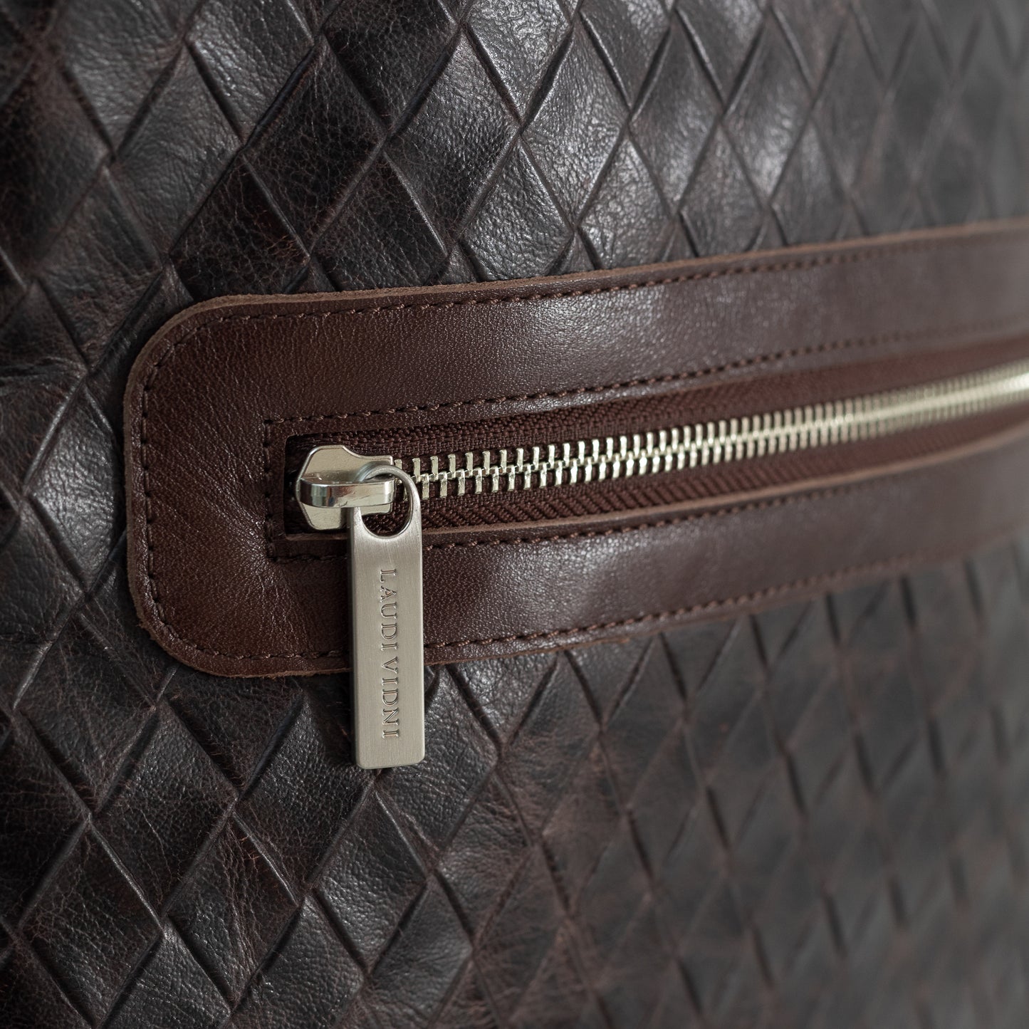 A close up picture of the zipper in the Moto Large Backpack in Basketweave Brown. You can see the leather texture clearly in the photo.