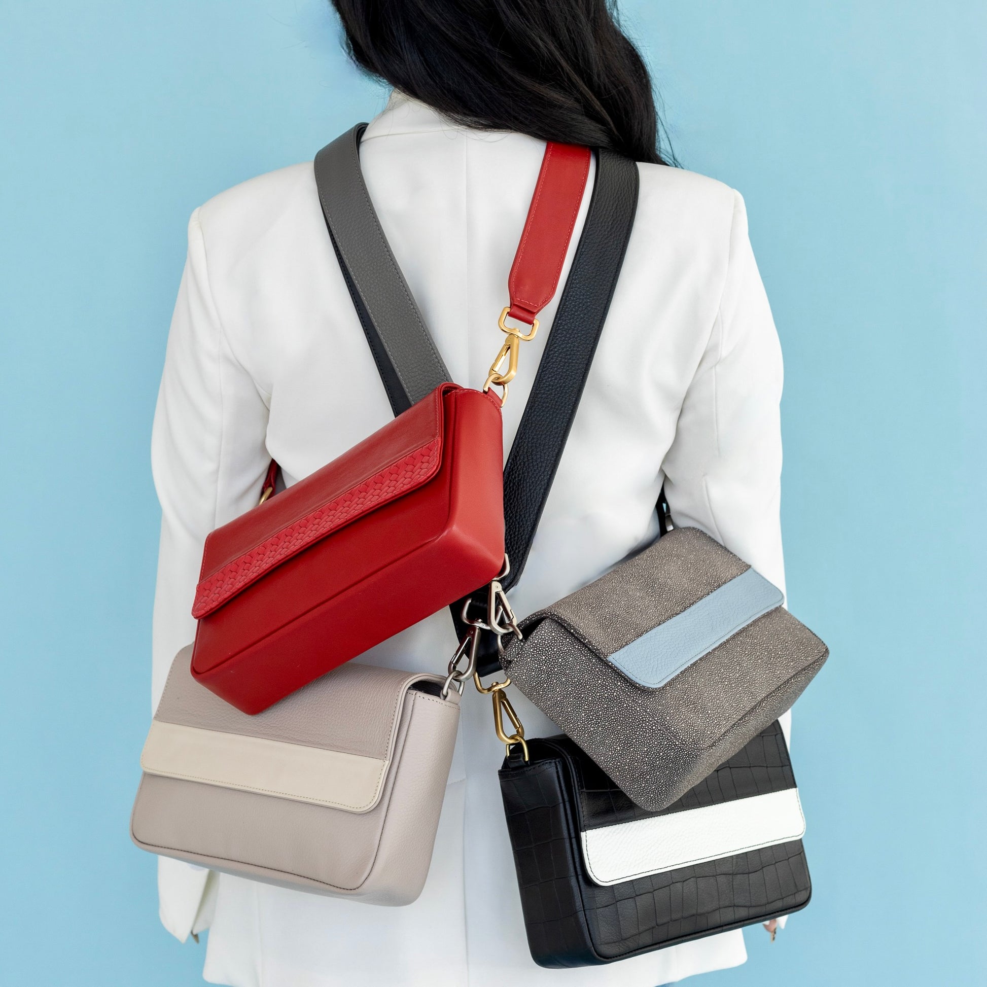 woman holding 4 laudi vidni prima crossbody bags