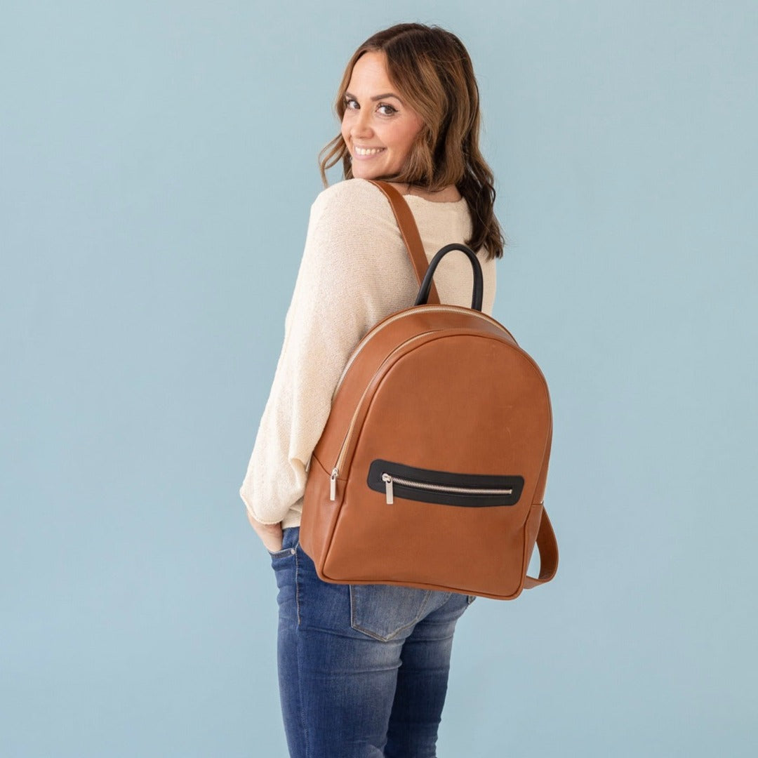 Woman is wearing a Moto Large backpack in Chestnut.