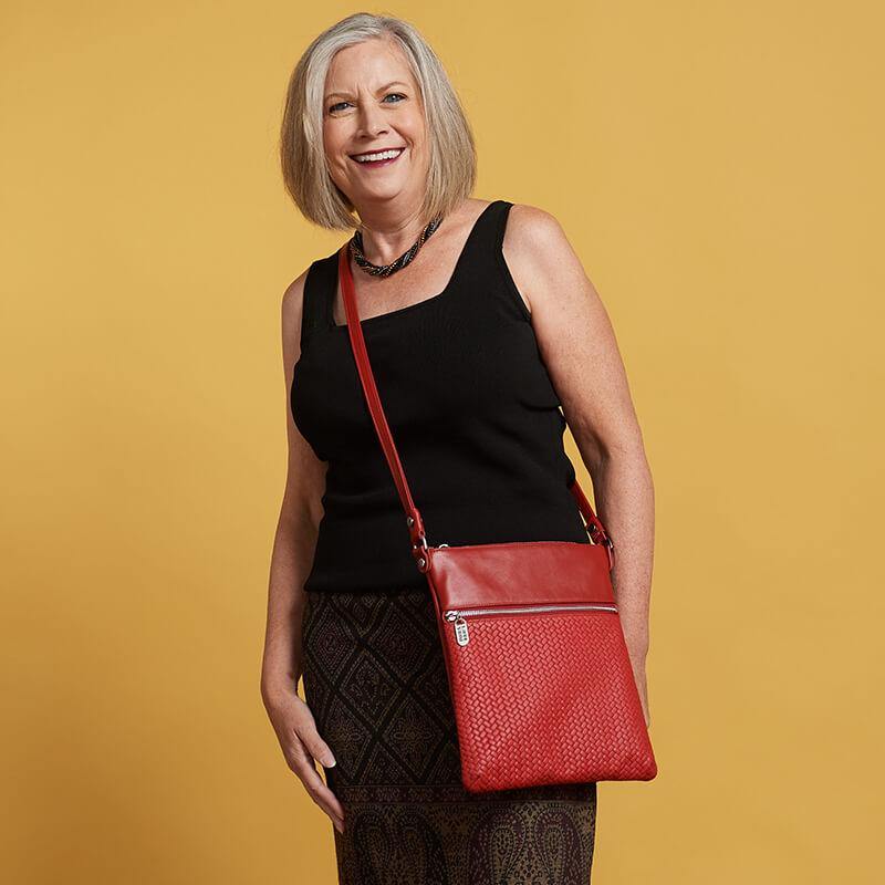 Woman wears Laudi Vidni Aria Crossbody in Woven Red and Cayenne.