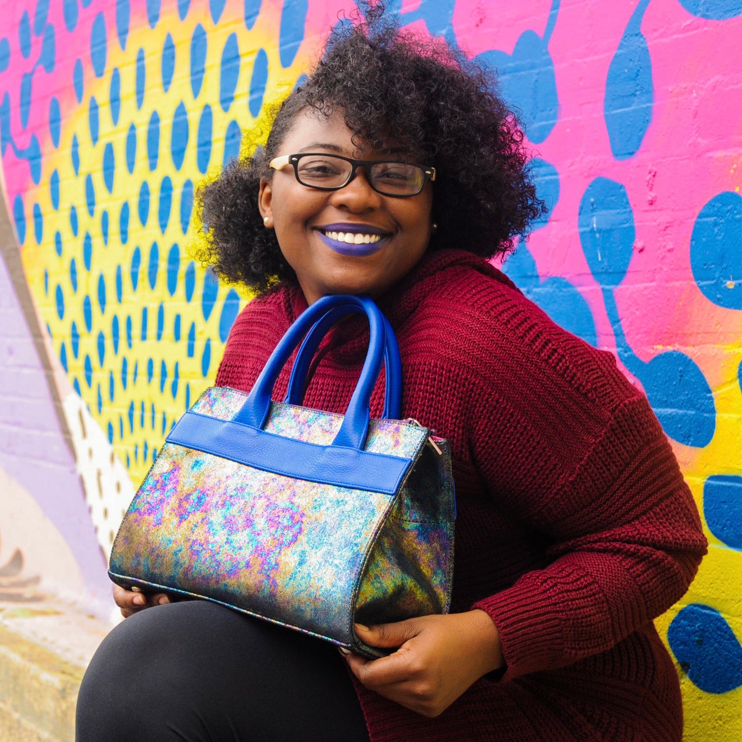 woman holding laudi vidni courante carryall iridescent metallic leather