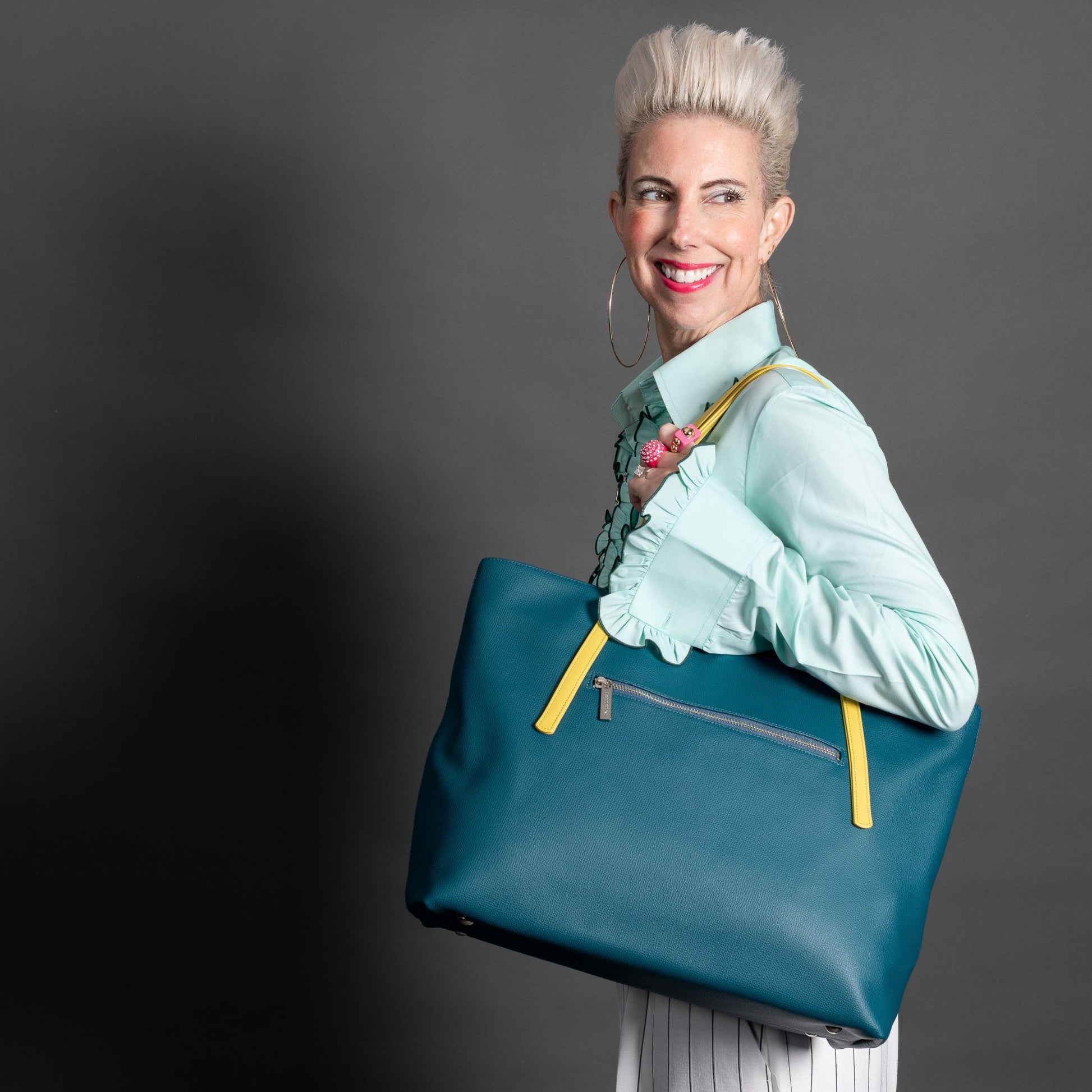woman holding tote bag in peacock leather
