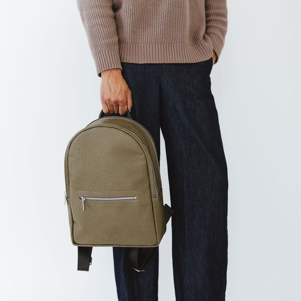 Motto Medium Backpack in Savanna Moss/Black Model Holding Strap