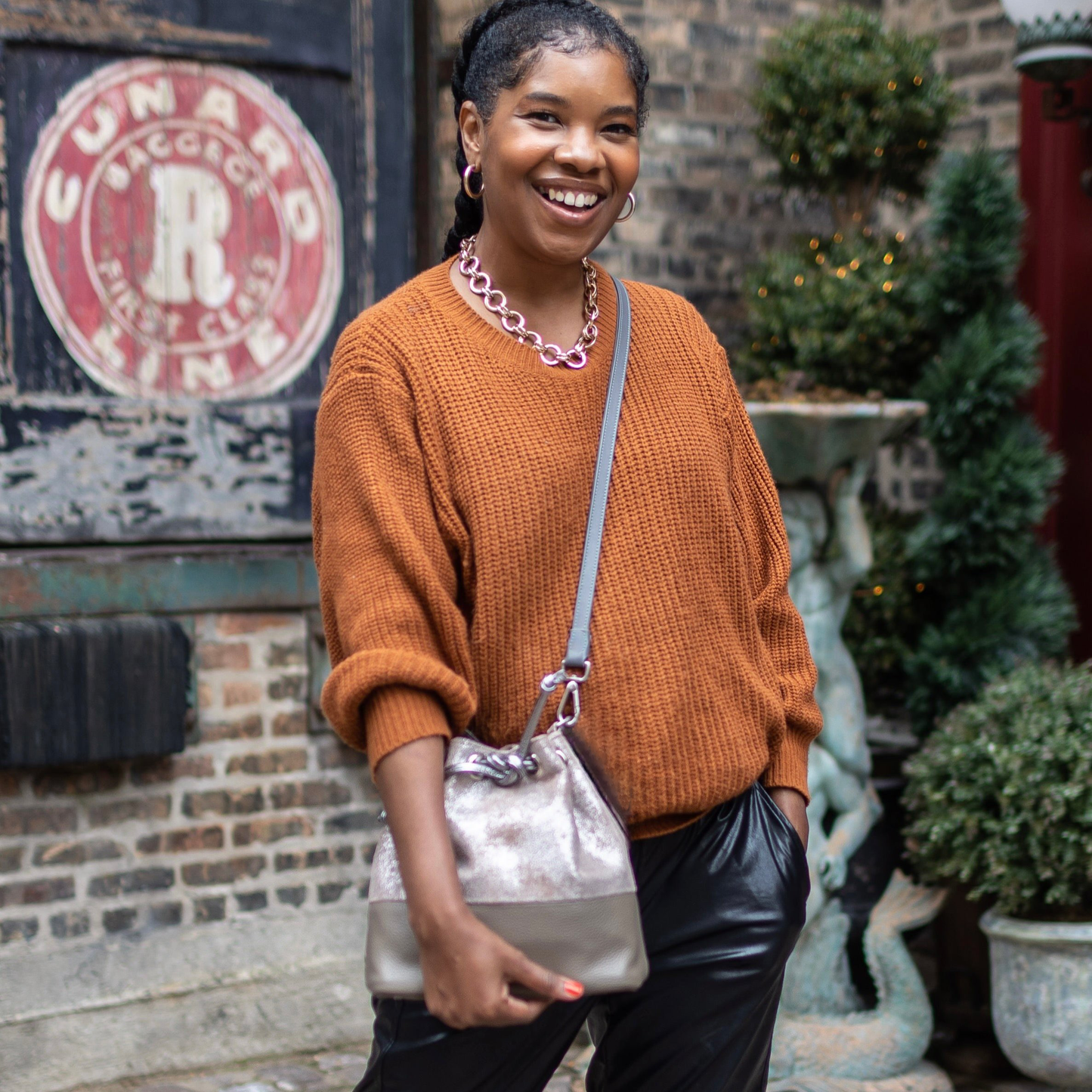 woman carrying laudi vidni brio crossbody bag in jet set taupe leather