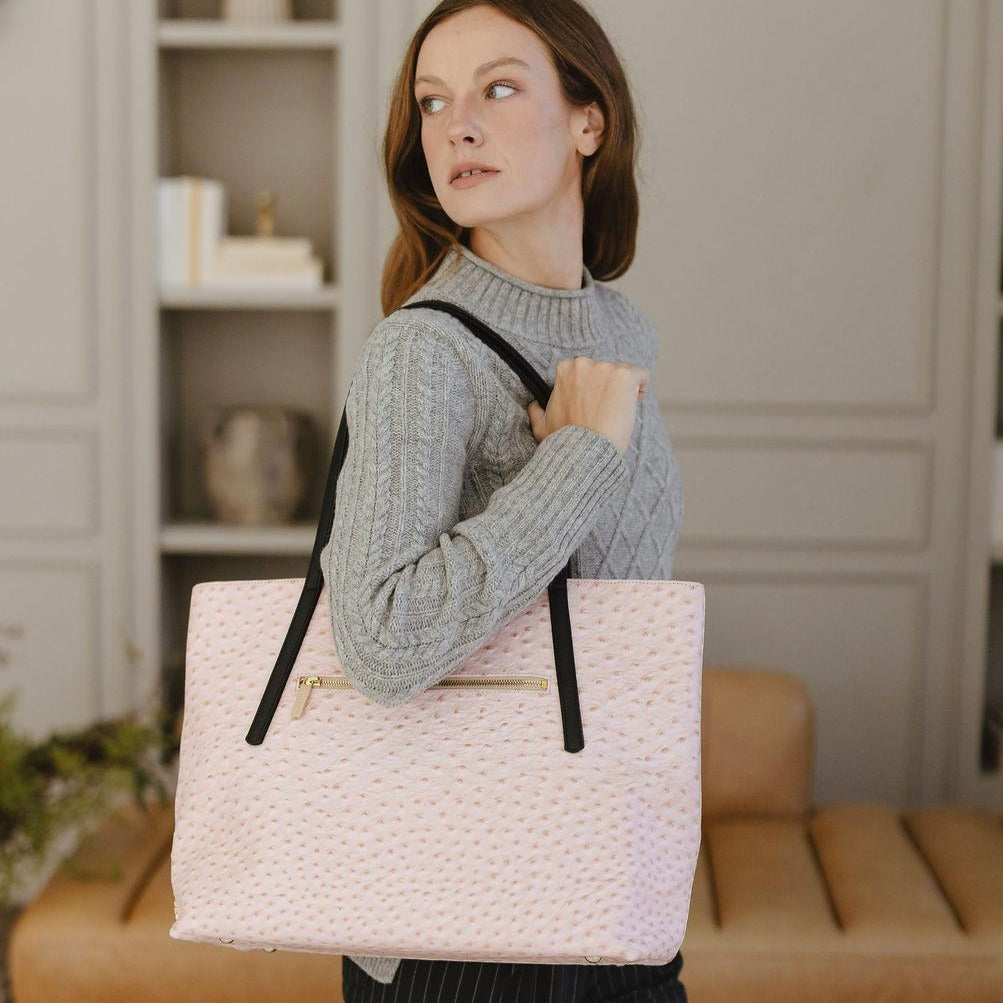woman holding a laudi vidni opus large tote in ostrich pink leather
